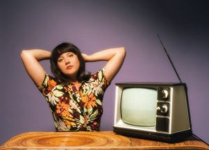 Caitlin Rose next to an old TV