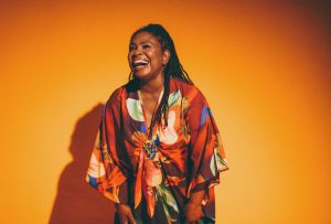 Ruthie Foster in a colorful print dress laughs